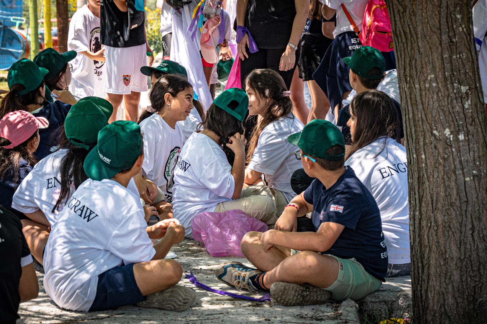 Participants sitting together under a tree, sharing a moment of rest and conversation after the plogging activity